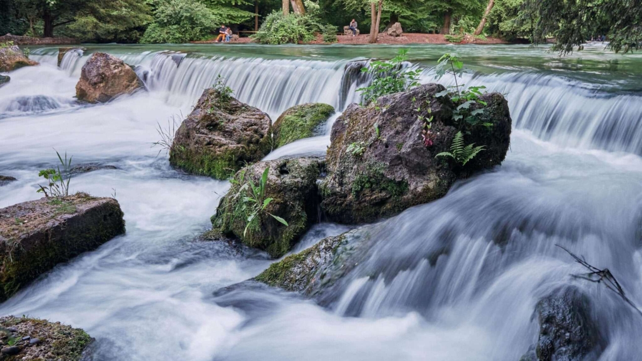 Klares Wasser und grüne Ufer am Eisbach – Münchens beliebte Naturoase