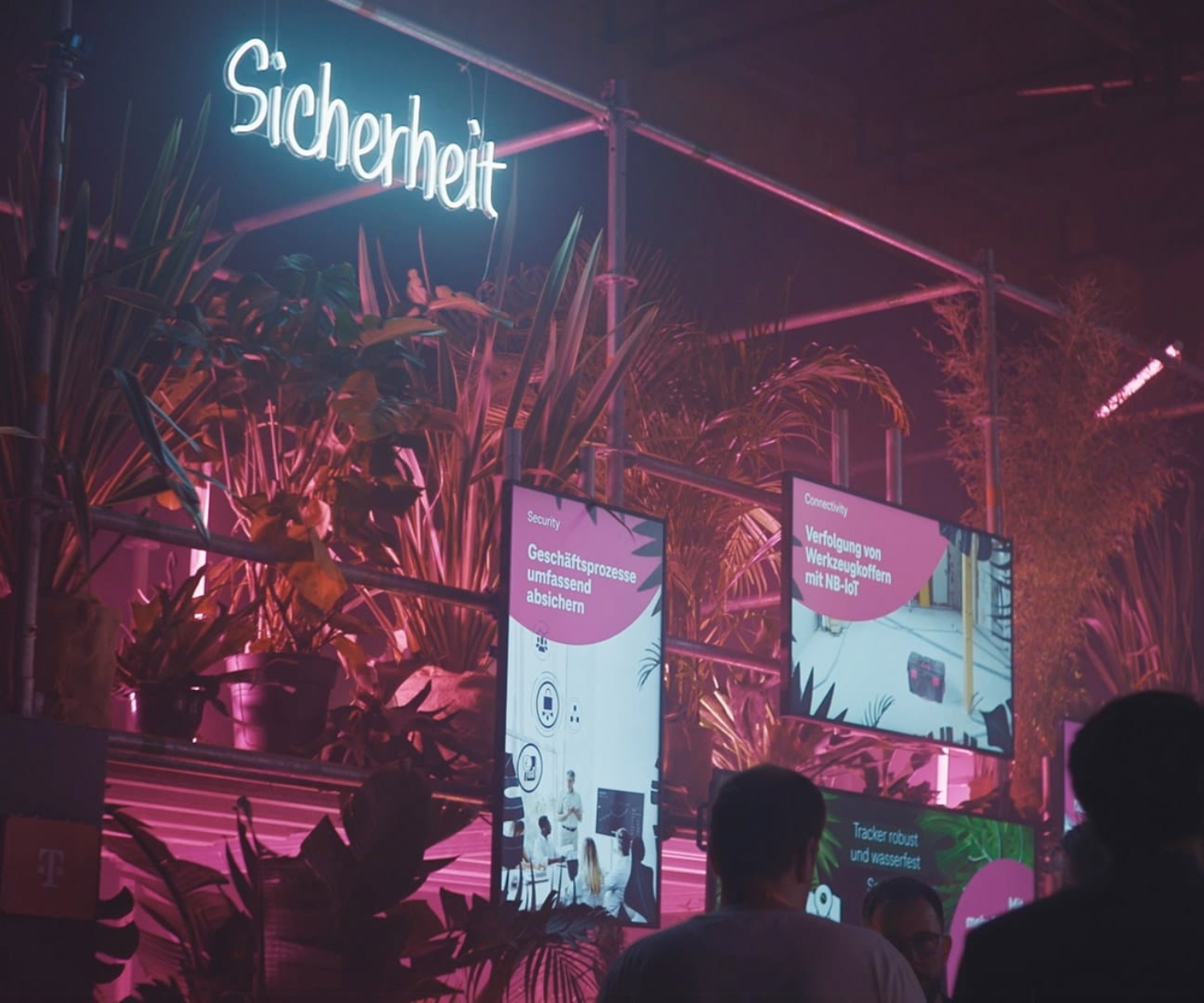 Blick auf die neonbeleuchtete Messefläche zum Thema Sicherheit mit digitalen Displays und Pflanzen auf der DIGITAL X 2023 in Köln