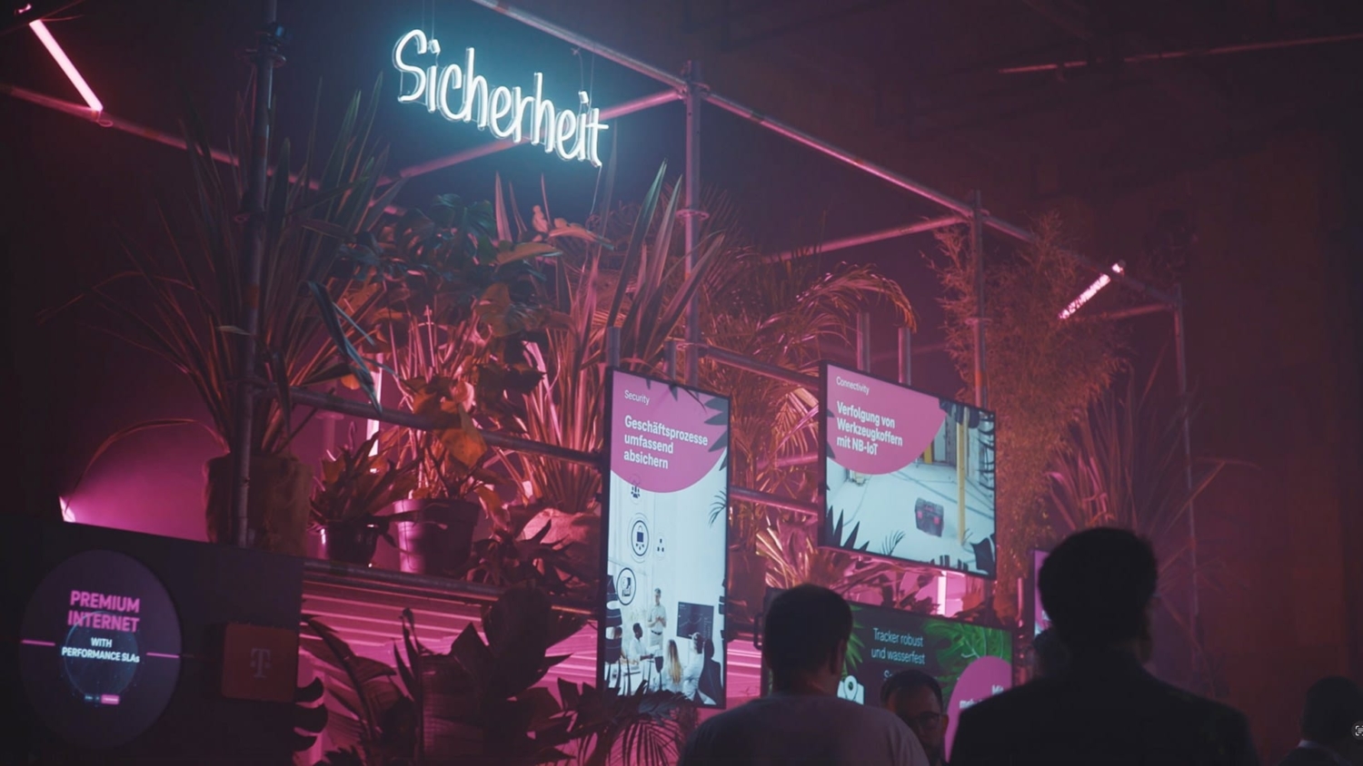 Blick auf die neonbeleuchtete Messefläche zum Thema Sicherheit mit digitalen Displays und Pflanzen auf der DIGITAL X 2023 in Köln