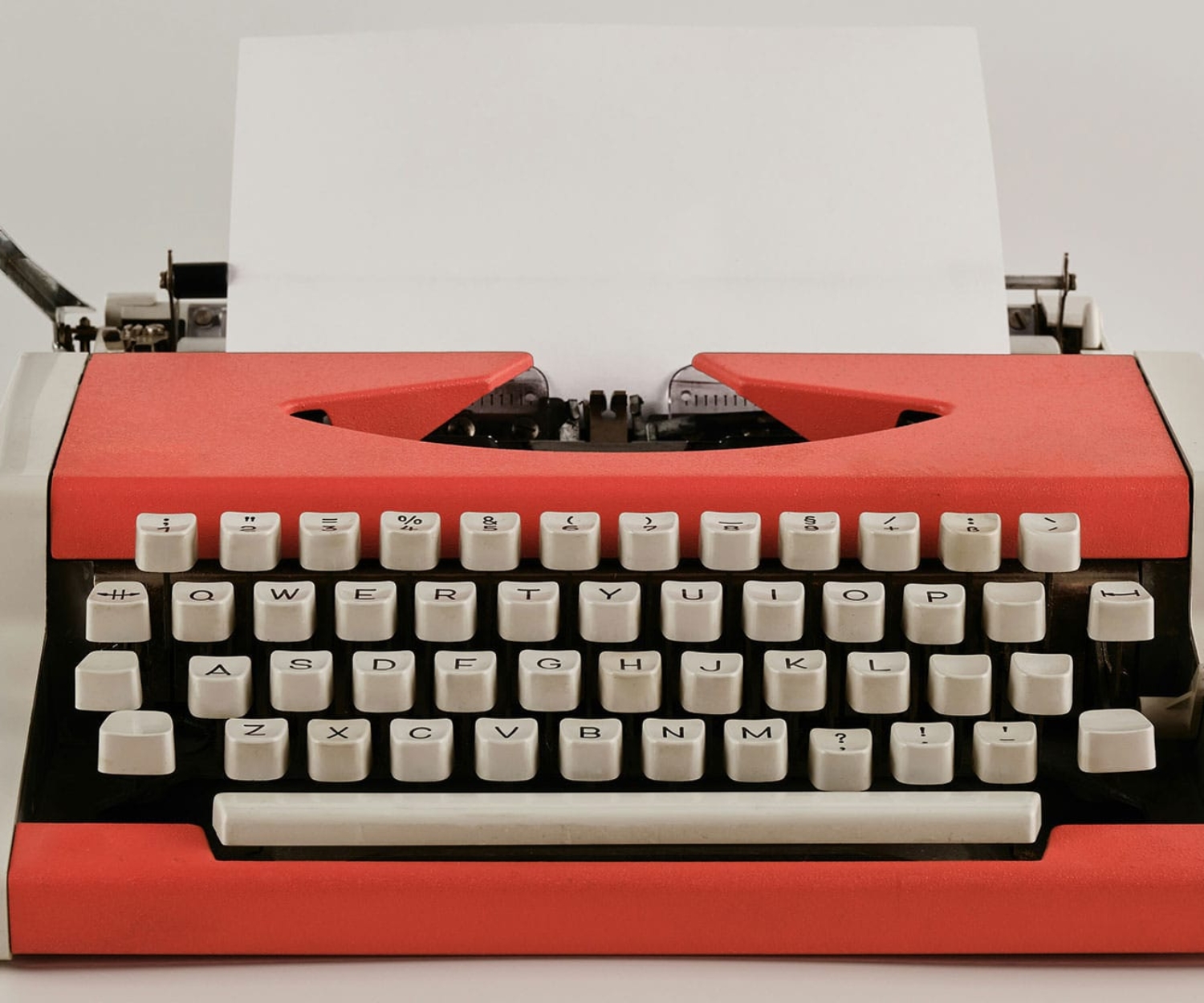 Rote Schreibmaschine mit Papier – Symbol für kreatives Schreiben und Drehbuchentwicklung
