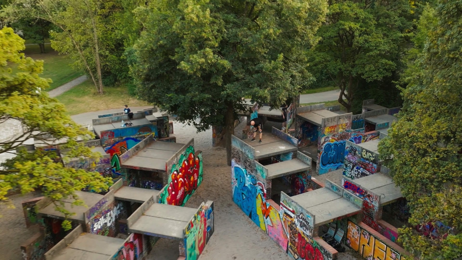 Vogelperspektive auf das Parkour-Areal im Olympiapark München mit bunten Graffiti-Wänden und urbanem Layout
