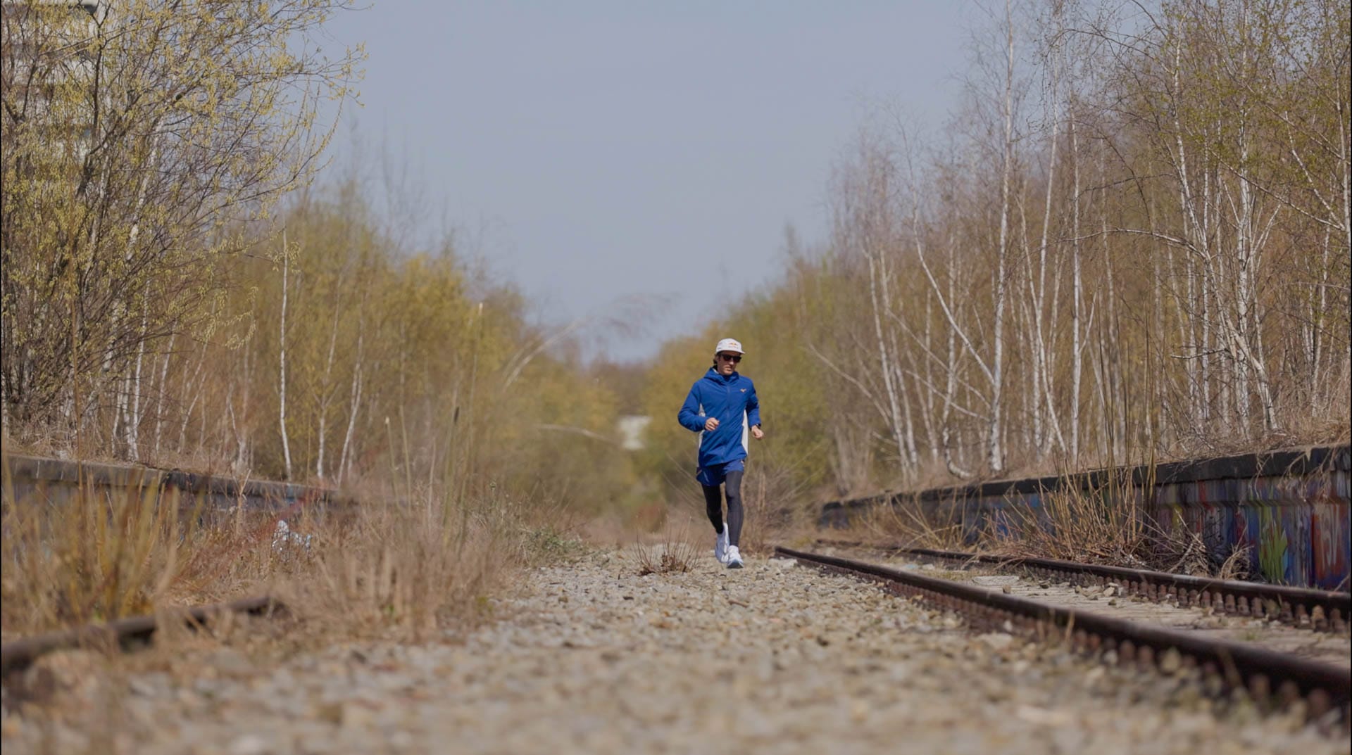 Ultraläufer Florian Neuschwander läuft auf den stillgelegten Gleisen im Münchner Olympiapark bei Sonnenschein