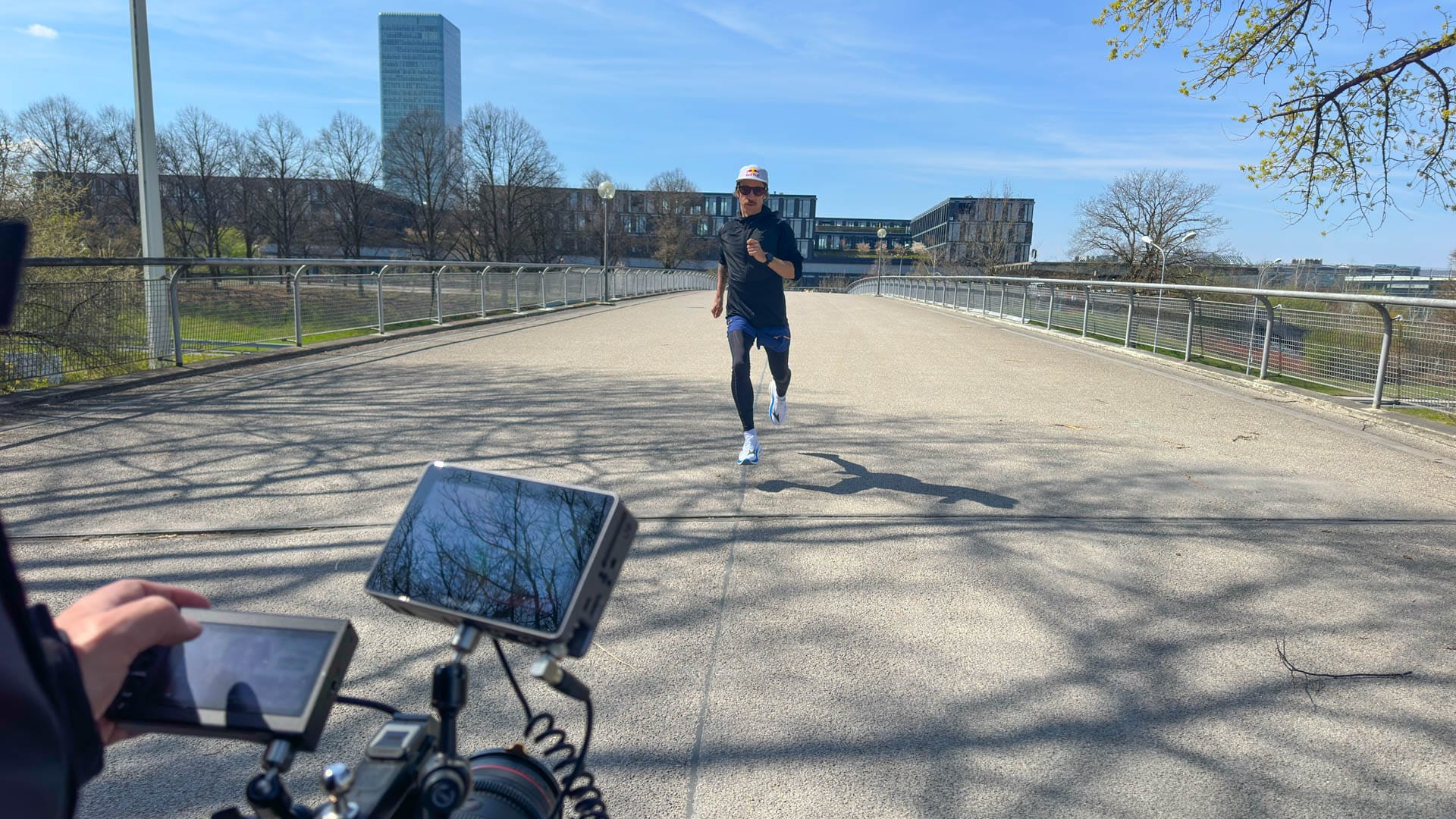 Laufaufnahme mit Flo Neuschwander im Olympiapark, im Vordergrund Kameraequipment und Monitore
