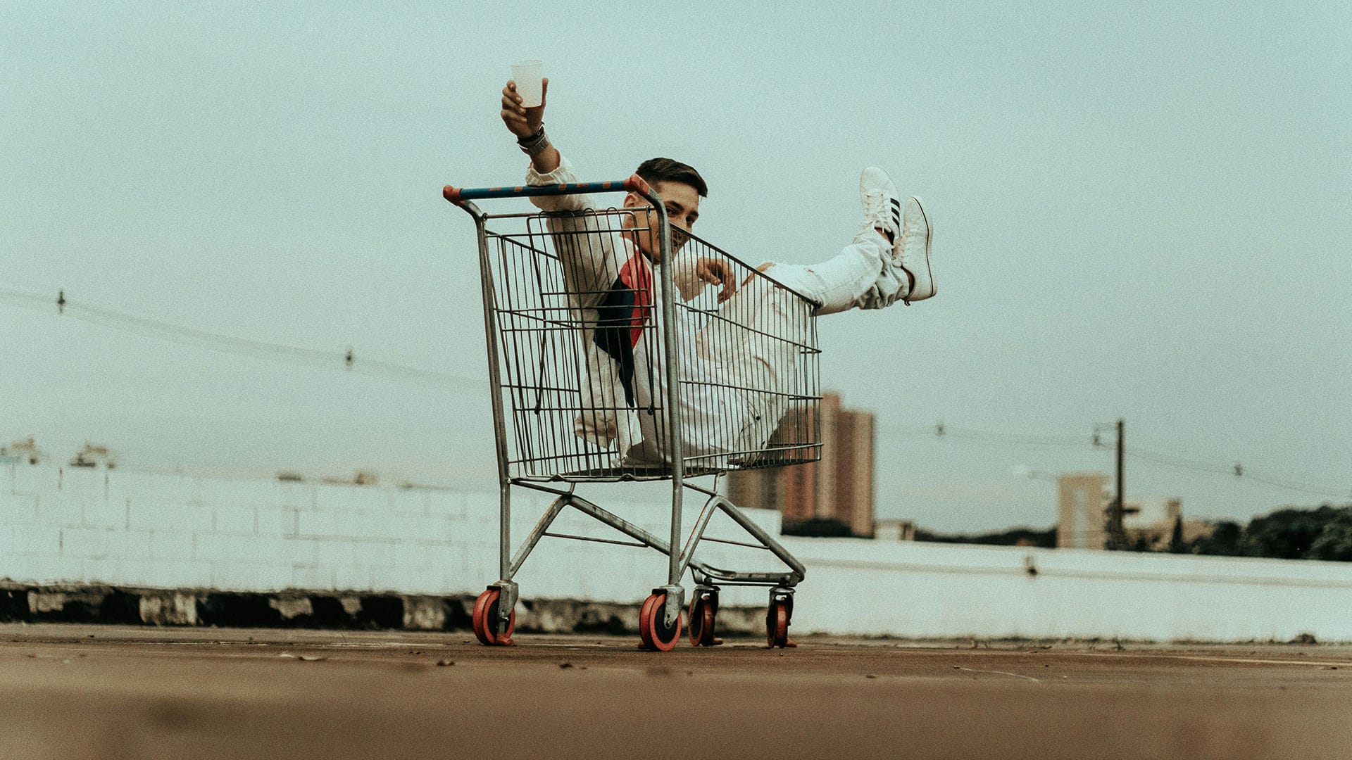 Junger Mann im Einkaufswagen als Metapher für spontane Kaufentscheidungen und die Bedeutung von Videoinhalten in der Customer Journey