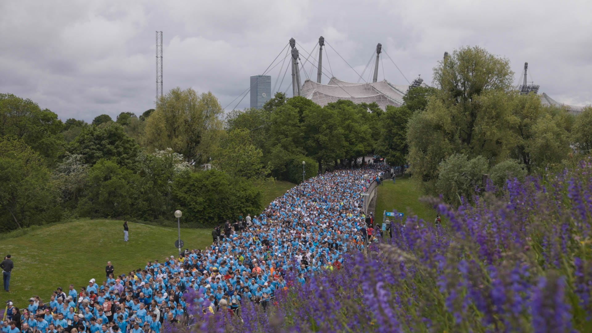 Läuferinnen und Läufer beim Wings for Life World Run 2025 im Olympiapark München vor der Kulisse des Olympiastadions