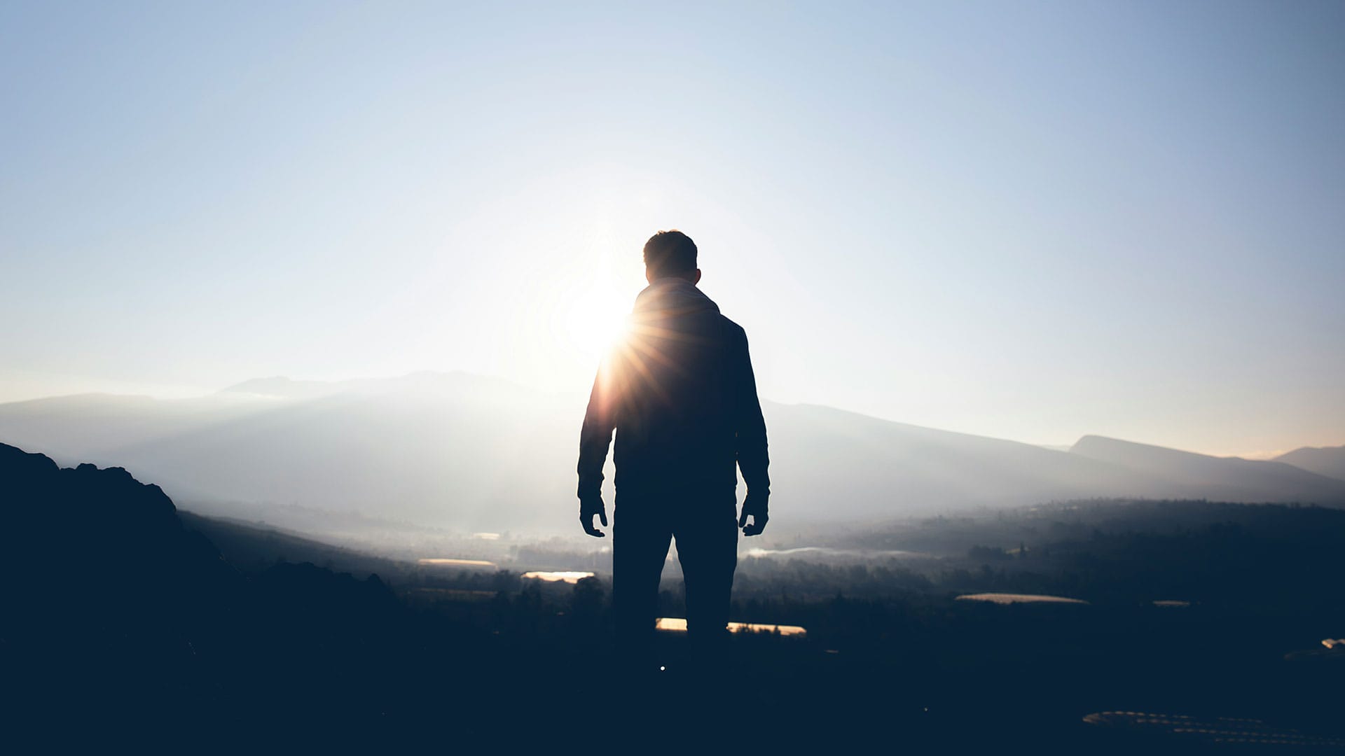 Person im Gegenlicht vor einer weiten Landschaft – symbolische Aufnahme für emotionale Bildsprache in der B2B-Videoproduktion