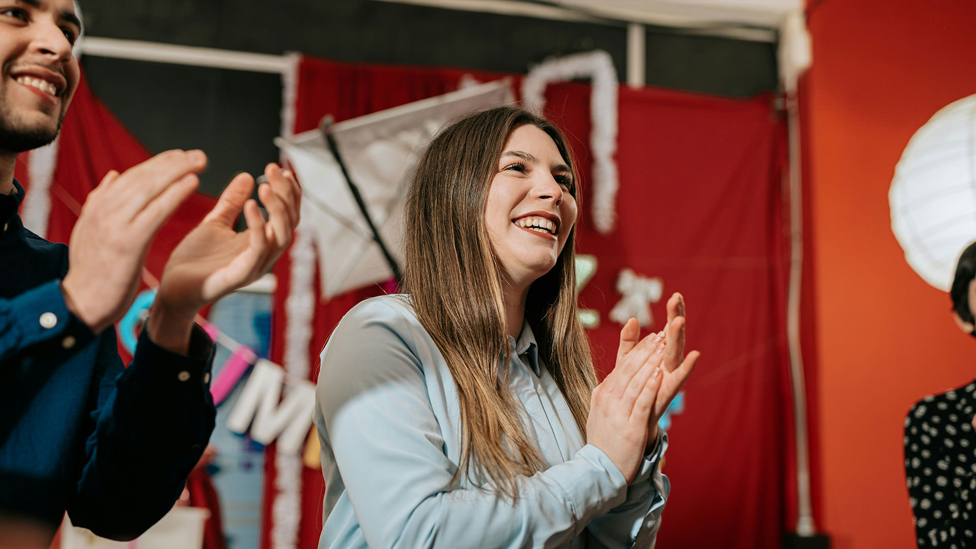 Junge Frau applaudiert bei einem Live-Streaming-Event für Unternehmen und zeigt emotionale Beteiligung
