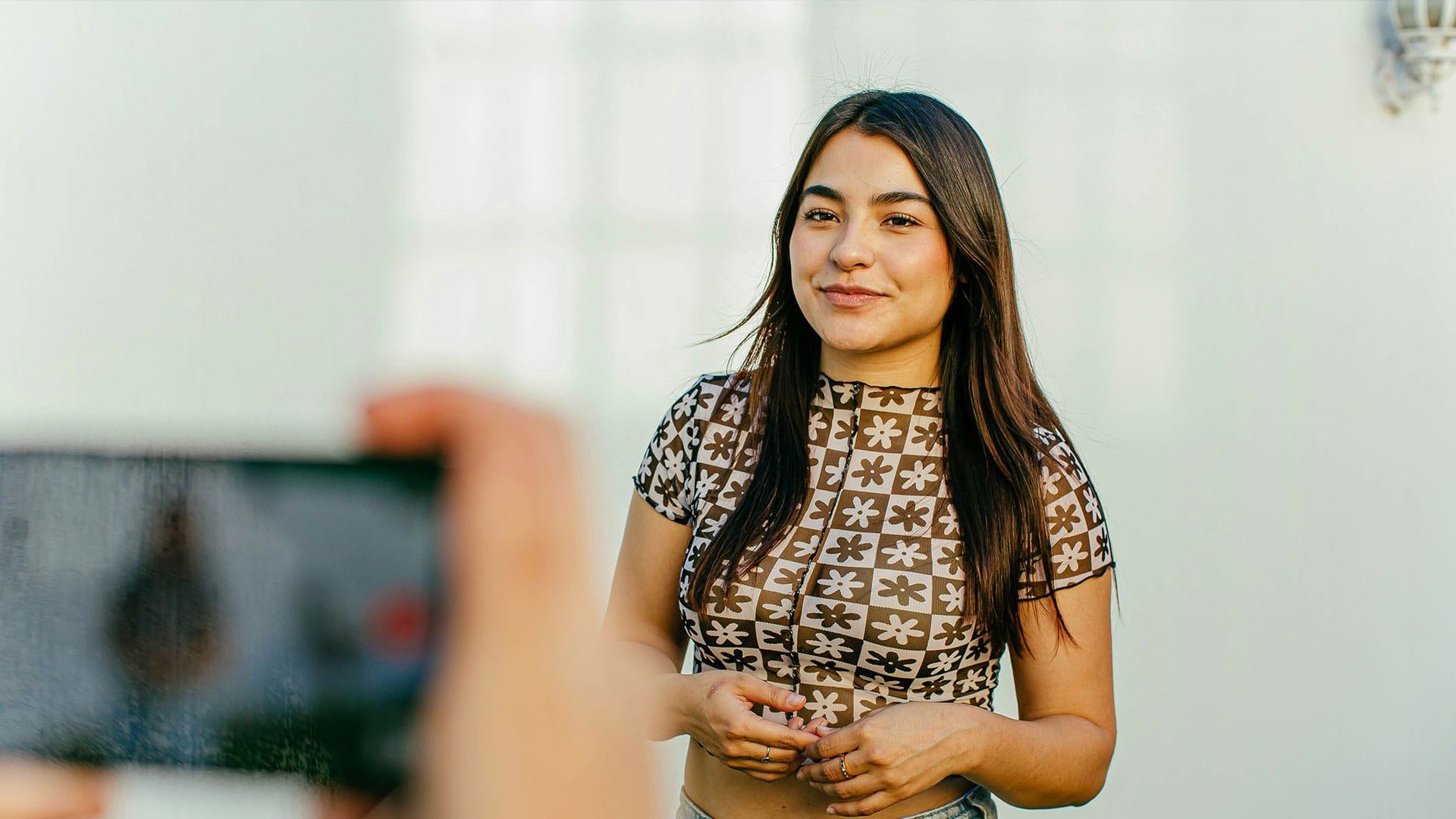 Echte Nutzerin steht vor der Kamera und wird beim Erstellen von User-Generated Content im Unternehmensvideo gefilmt