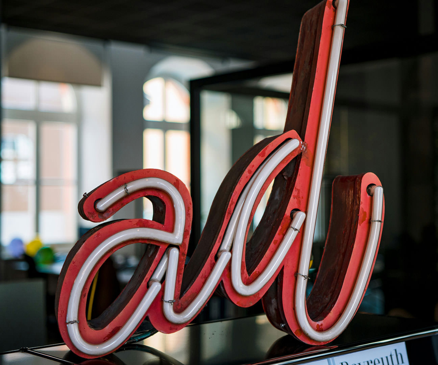 Rotes „On Air“-Leuchtschild an schwarzer Wand, Symbol für aktive Video-Podcast-Aufnahme