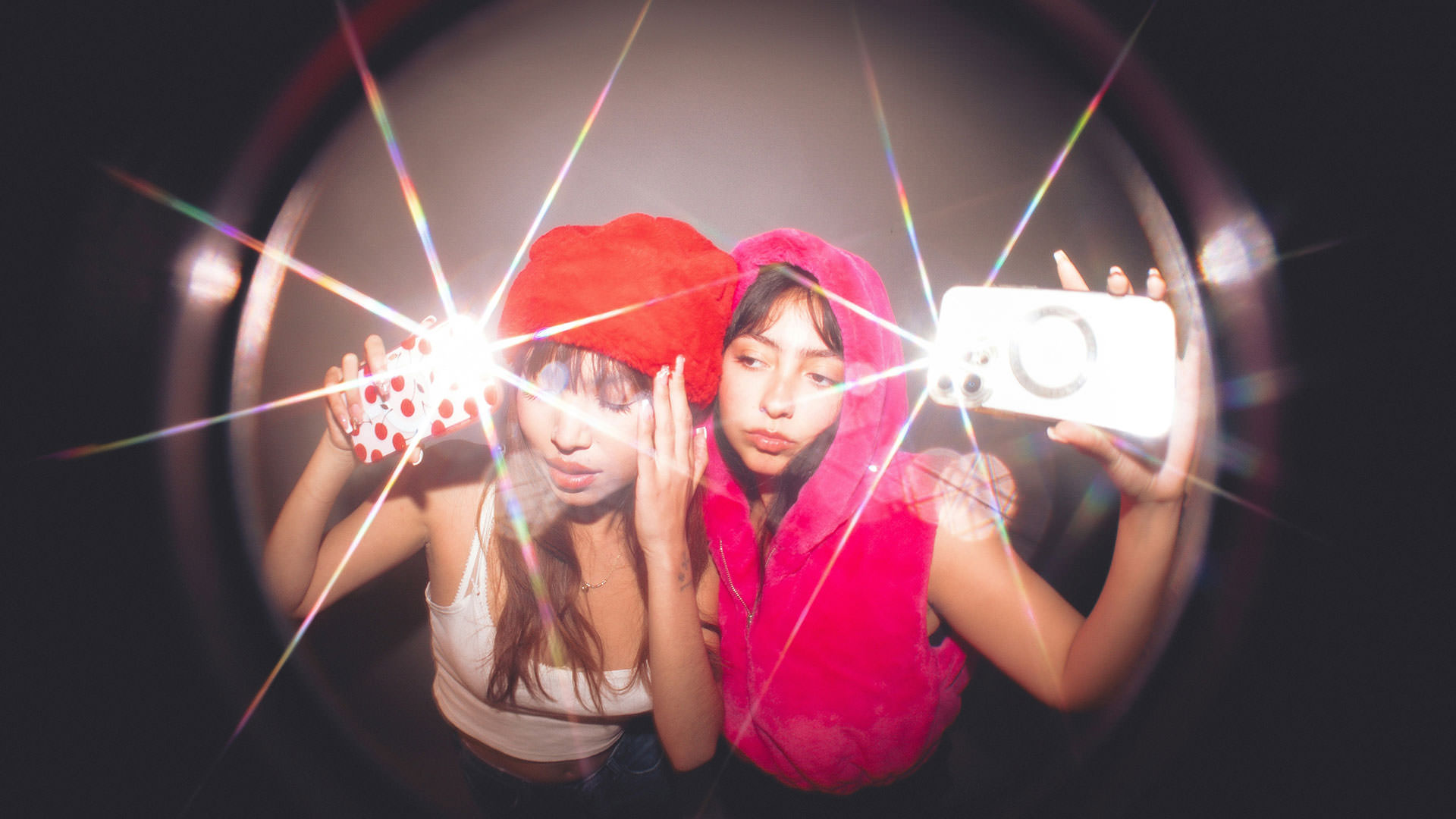 Zwei junge Frauen nehmen ein Selfie mit Lichteffekt auf – kreativer Content für Kurzvideos für Unternehmen