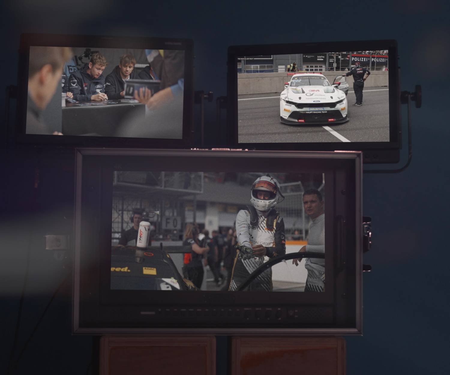 Drei Monitore zeigen Szenen aus den ADAC GT Masters und ADAC GT4 Germany Jahresfilmen 2025 – Motorsportfilmproduktion im Studio