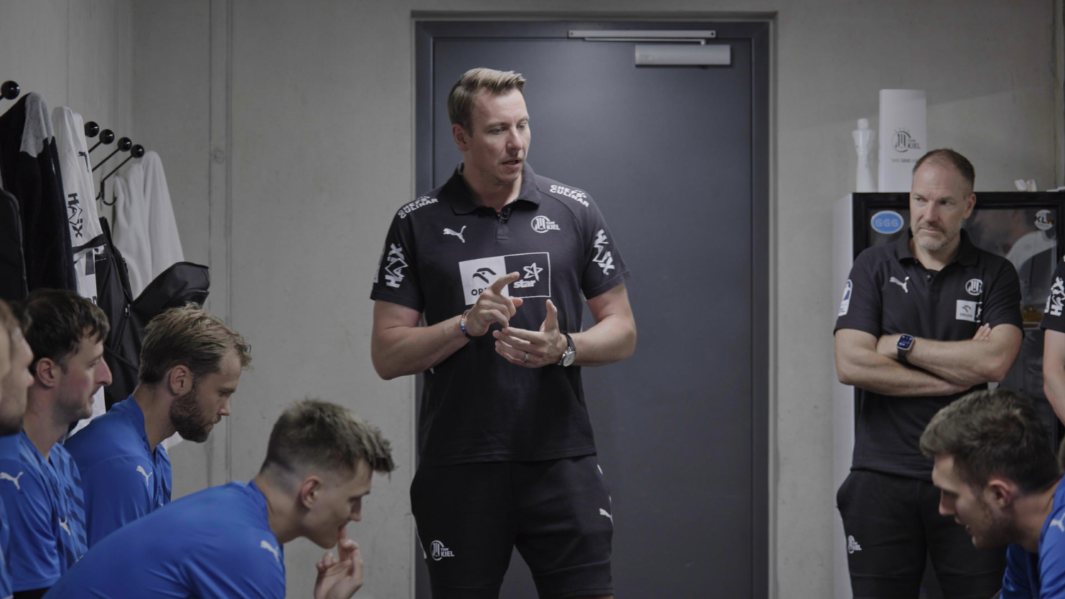 Filip Jicha spricht das THW Kiel Team in der Kabine an – Szene aus der Dyn Doku Grip of Glory